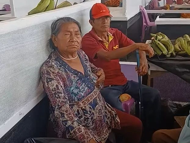 Comerciantes en sus puestos con racimos de plátano